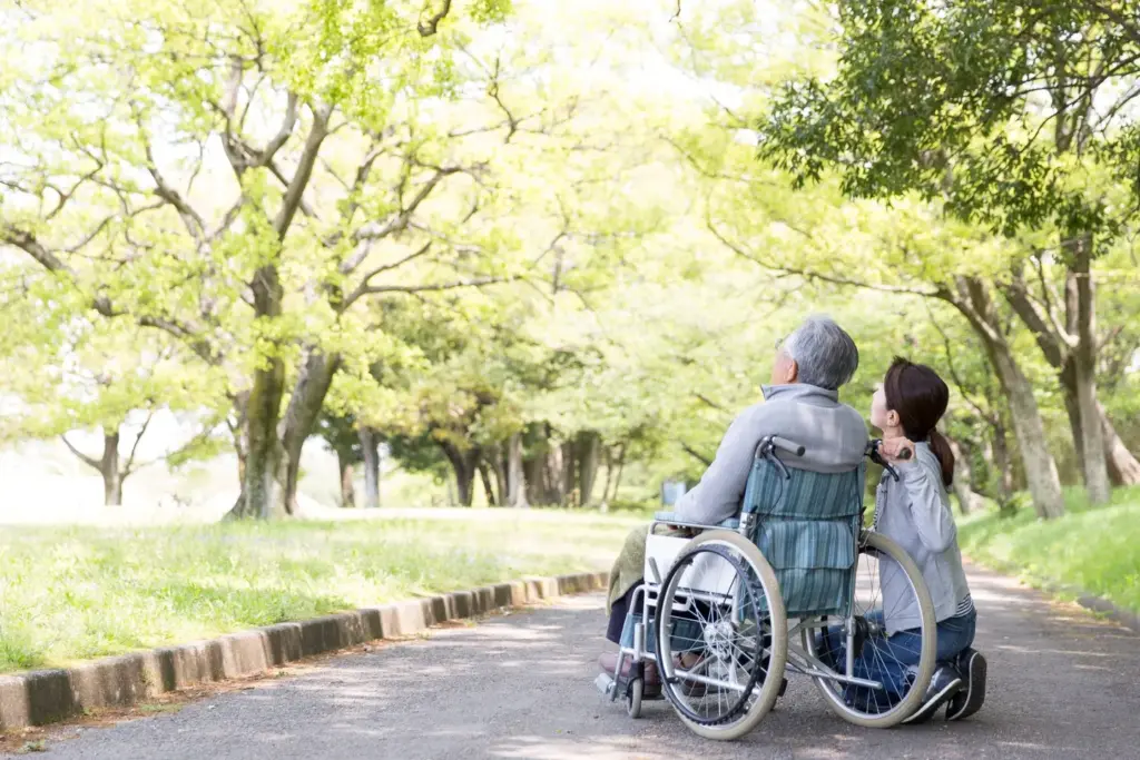 介護施設で屋外散歩をしているお年寄りとスタッフ